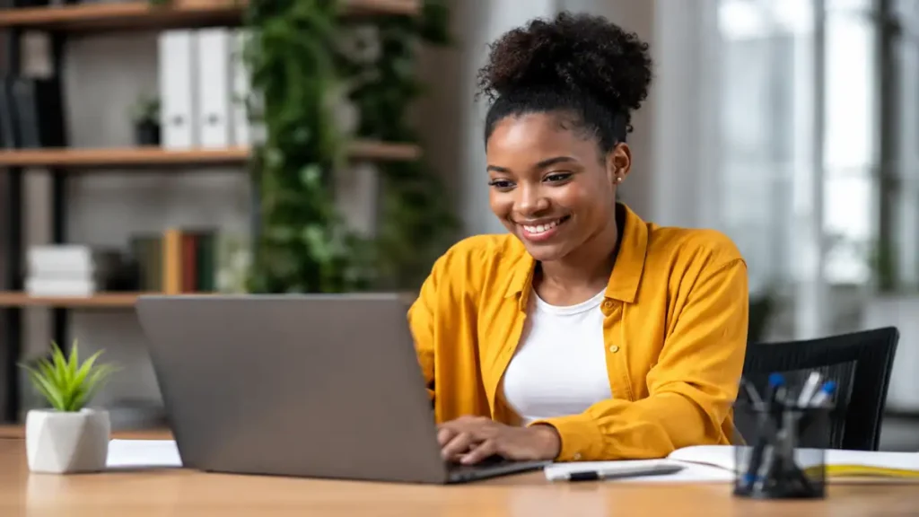 Young South African learner creating a professional CV Format for learnership applications on a laptop in a modern office environment